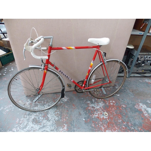 12 - A VINTAGE RED PEUGEOT TOUR 10 MENS RACING BIKE WITH QUICK RELEASE FRONT WHEEL AND 10 SPEED GEAR SYST... 