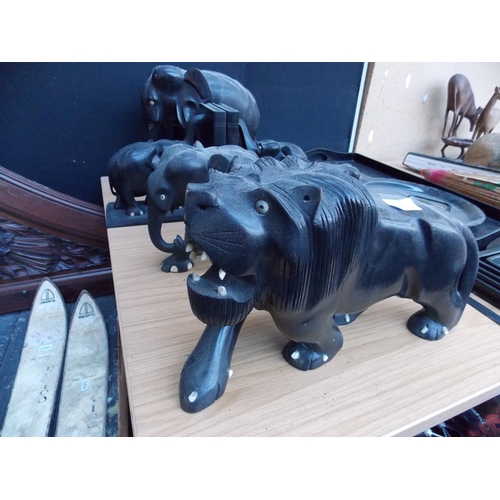 1057 - NINE CARVED EBONY ANIMAL FIGURES TO INCLUDE AN UNUSUAL LION FIGURE, TWO PAIRS OF ELEPHANT EBONY BOOK... 