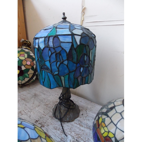 1063 - A DECORATIVE BLUE AND GREEN TIFFANY STYLE TABLE LAMP ON A BRASS BASE