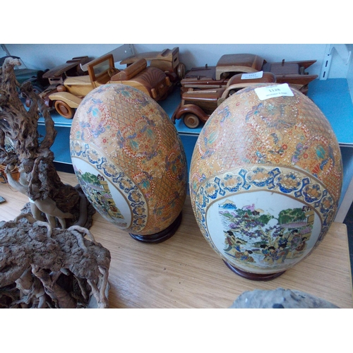 1128 - A PAIR OF EXCELLENT QUALITY ORIENTAL HAND PAINTED TUBE LINED DECORATIVE EGGS ON HARD WOOD BASE