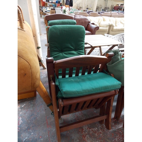 32 - THREE TEAK GREEN UPHOLSTERED FOLDING GARDEN CHAIRS