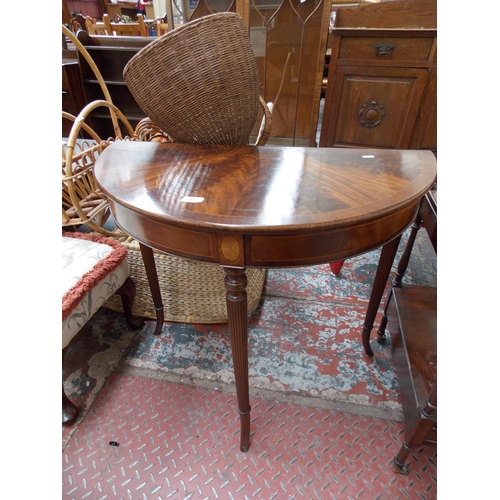 561 - A FLAMED MAHOGANY OVAL HALL TABLE WITH FAN INLAY AND THREE REEDED SUPPORTS