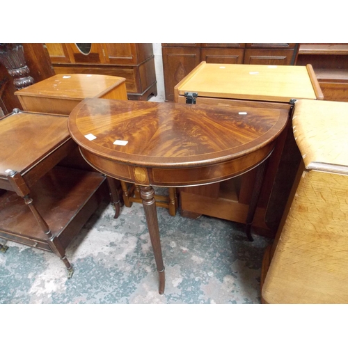 561 - A FLAMED MAHOGANY OVAL HALL TABLE WITH FAN INLAY AND THREE REEDED SUPPORTS