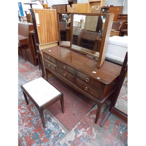 597 - A STAG MAHOGANY DRESSING TABLE WITH SIX DRAWERS, THREE SECTIONED MIRROR AND A STOOL