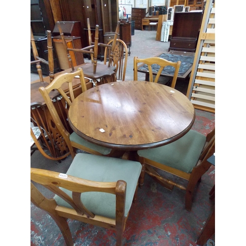 641 - A PINE CENTRE PEDESTAL DINING TABLE WITH FOUR MATCHING GREEN UPHOLSTERED CHAIRS