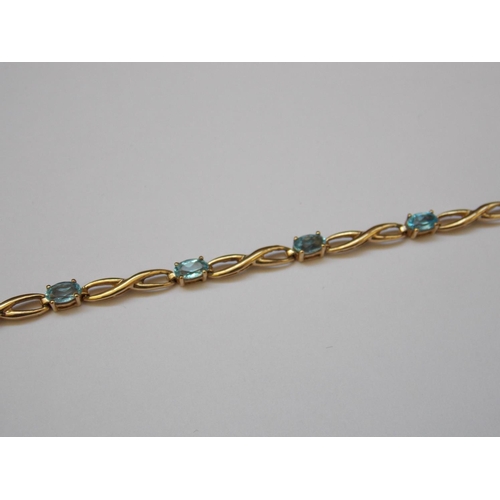 463 - A 9 CARAT GOLD BLUE TOPAZ BRACELET