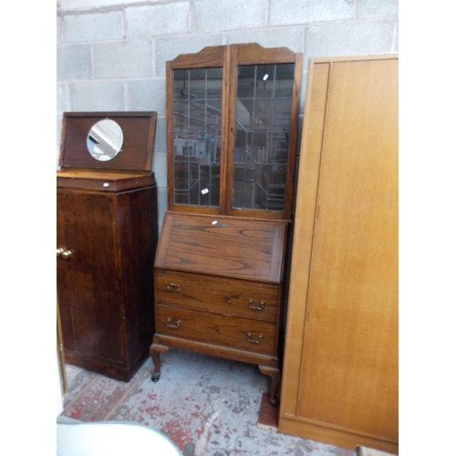 538 - AN OAK BUREAU BOOKCASE WITH TWO UPPER LEADED GLASS DOORS AND TWO LOWER DRAWERS