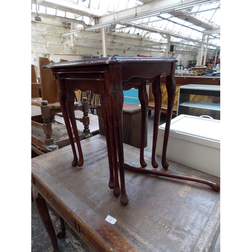 552 - A BURR WALNUT DESK ON BALL AND CLAW FEET AND A MAHOGANY NEST OF THREE TABLES