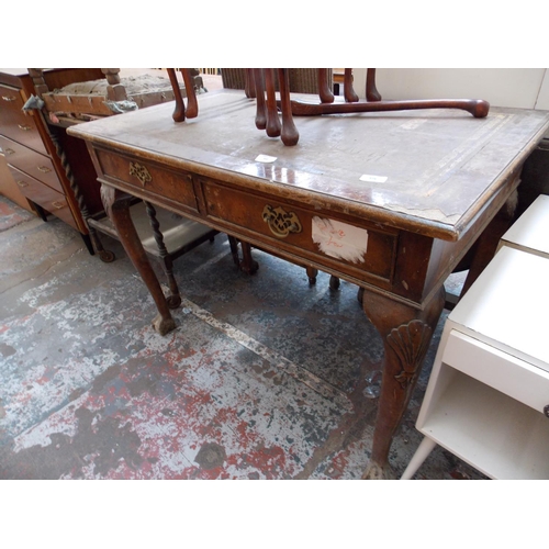 552 - A BURR WALNUT DESK ON BALL AND CLAW FEET AND A MAHOGANY NEST OF THREE TABLES