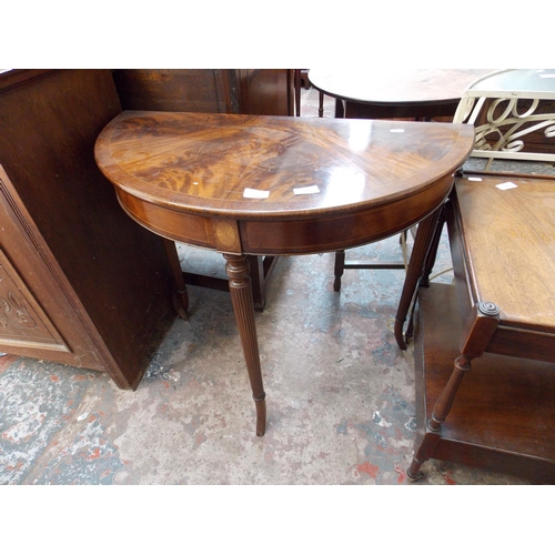 561 - A FLAMED MAHOGANY OVAL HALL TABLE WITH FAN INLAY AND THREE REEDED SUPPORTS