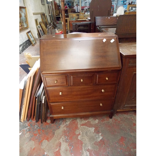 563 - A STAG MAHOGANY BUREAU WITH FIVE DRAWERS AND A FALL FRONT