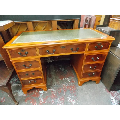 581 - A YEW WOOD OFFICE DESK WITH NINE DRAWERS AND GREEN LEATHER INSERT