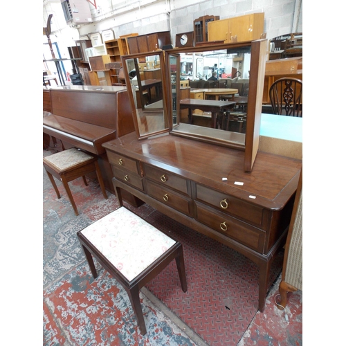 597 - A STAG MAHOGANY DRESSING TABLE WITH SIX DRAWERS, THREE SECTIONED MIRROR AND A STOOL