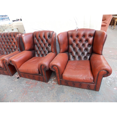 618 - AN OXBLOOD CHESTERFIELD SOFA AND TWO MATCHING ARMCHAIRS