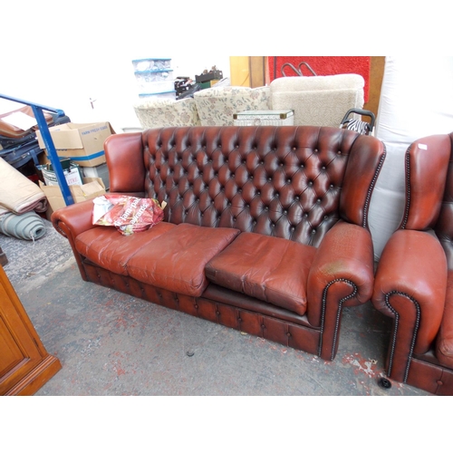 618 - AN OXBLOOD CHESTERFIELD SOFA AND TWO MATCHING ARMCHAIRS