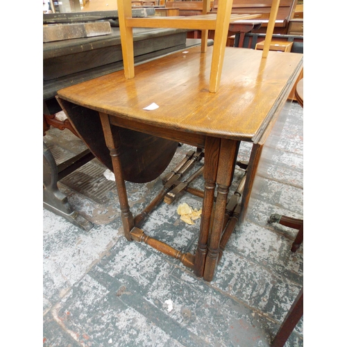 649 - A GOLDEN OAK DROP LEAF DINING TABLE AND A TEAK COFFEE TABLE