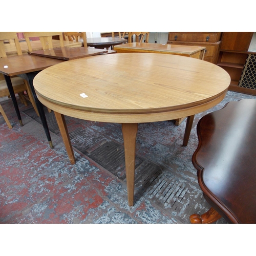 652 - A ROUND LIGHT OAK DINING TABLE