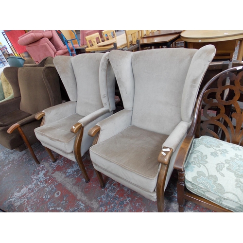 674 - A PAIR OF BEIGE UPHOLSTERED WINGBACK CHAIRS