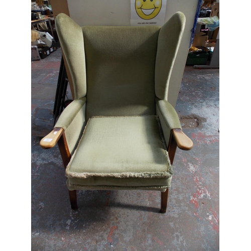 676 - A GREEN DRALON WINGBACK CHAIR