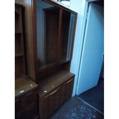 549 - A TEAK EFFECT DRESSER WITH TWO GLASS DOORS AND TWO LOWER DOORS