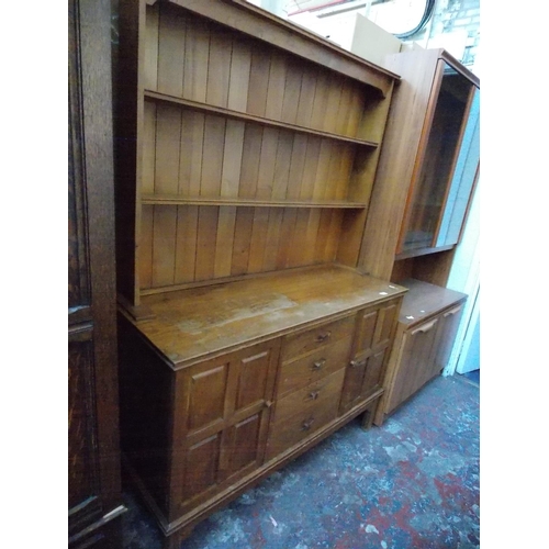 550 - A GOLDEN OAK ARTS AND CRAFTS DRESSER WITH TWO TIER UPPER PLATE RACK, TWO LOWER DOORS AND FOUR DRAWER... 