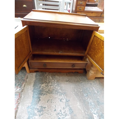 298 - AN OAK TV CABINET WITH TWO DRAWERS AND TWO DOORS