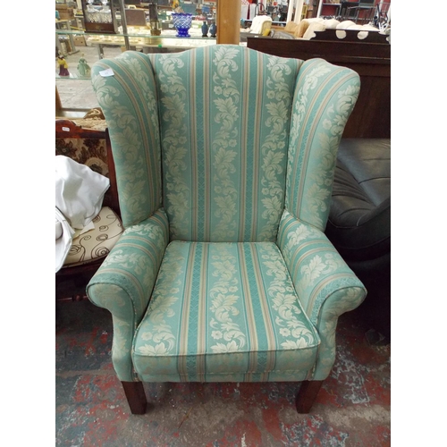 379 - A GREEN FLORAL WINGBACK ARM CHAIR