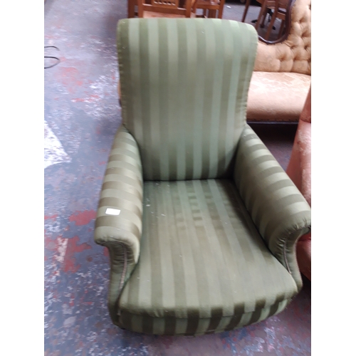 1227 - AN EARLY 20TH CENTURY HOWARD STYLE LOW SEATED GREEN STRIPED UPHOLSTERED ARM CHAIR ON CASTER SUPPORTS