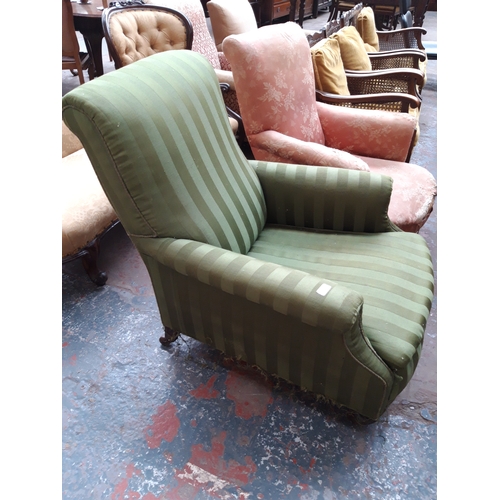 1227 - AN EARLY 20TH CENTURY HOWARD STYLE LOW SEATED GREEN STRIPED UPHOLSTERED ARM CHAIR ON CASTER SUPPORTS