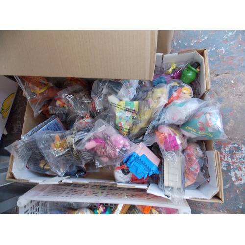 236 - THREE BOXES CONTAINING A LARGE QUANTITY OF VARIOUS MCDONALD'S HAPPY MEAL TOYS