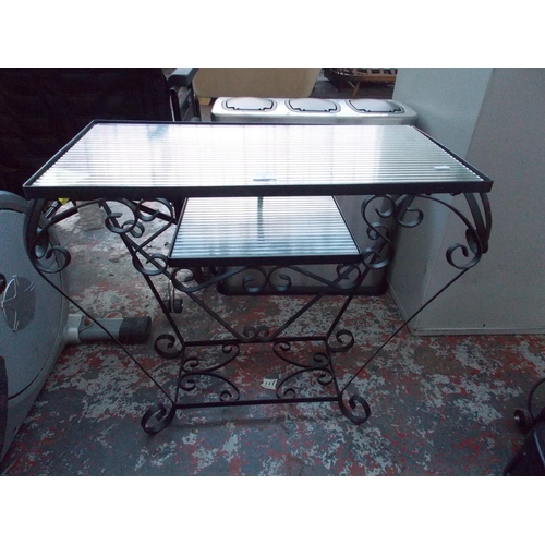 28 - A BLACK METAL ORNATE CONSERVATORY TABLE WITH TWO GLASS SHELVES