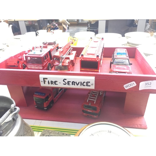 352 - A WOODEN MODEL FIRE STATION WITH SEVEN VARIOUS DIECAST MODEL FIRE TRUCKS TO INCLUDE DINKY AND CORGI