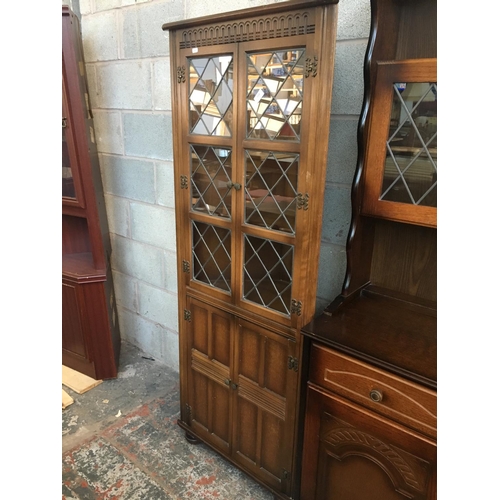 518 - AN OAK FREE STANDING CORNER CABINET WITH TWO LOWER DOORS AND TWO UPPER GLASS DOORS