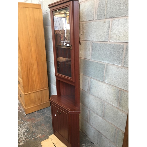 519 - A MAHOGANY EFFECT FREESTANDING CORNER CABINET WITH AN UPPER GLAZED DOOR AND ONE LOWER DOOR