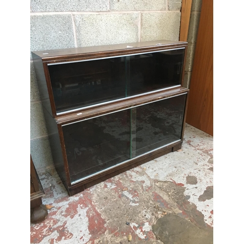 522 - A MINTY OAK TWO TIER BOOKCASE WITH FOUR GLASS SLIDING DOORS