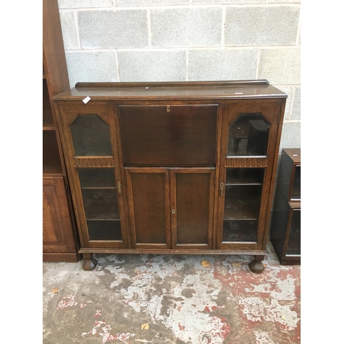 523 - AN ART DECO OAK BUREAU BOOKCASE WITH TWO GLASS DOORS, TWO LOWER DOORS AND A FALL FRONT