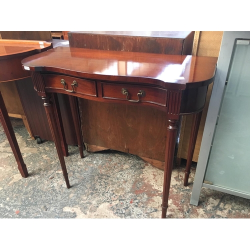 574 - A MAHOGANY SERPENTINE TWO DRAWER HALL TABLE WITH FLUTED LEGS