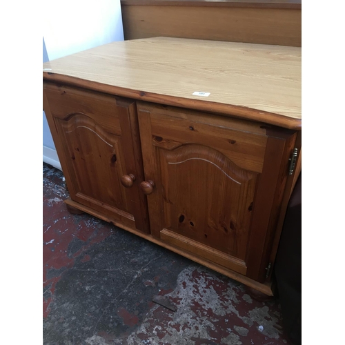 584 - TWO ITEMS TO INCLUDE A PINE TV STAND AND A WHITE PAINTED SIDEBOARD WITH THREE DRAWERS AND THREE DOOR... 