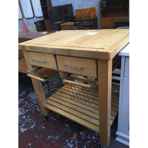 585 - A PINE KITCHEN TROLLEY/ISLAND WITH TWO BASKETS