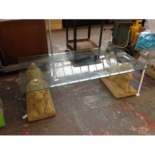 32 - A GOOD QUALITY RECTANGULAR BEVEL EDGE GLASS COFFEE TABLE WITH RECONSTITUTED STONE HEAVY LION FEET