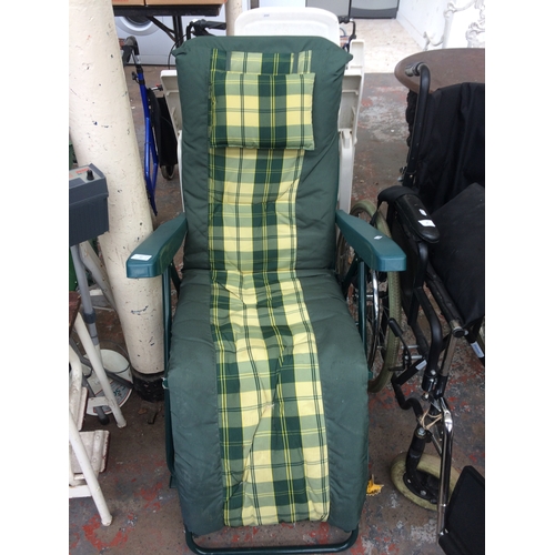 17 - THREE ITEMS TO INCLUDE A GREEN SUN LOUNGER WITH TARTAN UPHOLSTERY, THREE WHITE PLASTIC FOLDING PATIO... 