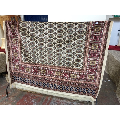 721 - A BEIGE GROUND BOKHARA CARPET MEASURING 2.8m x 2.0m