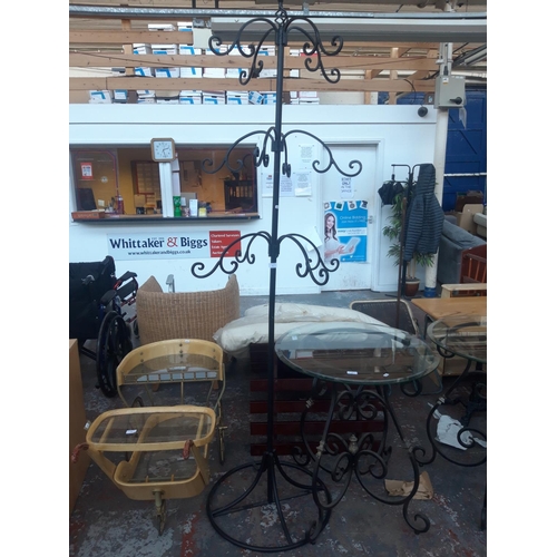 24 - A BLACK ORNATE WROUGHT IRON CLOTHES STAND MEASURING 7' TALL APPROX