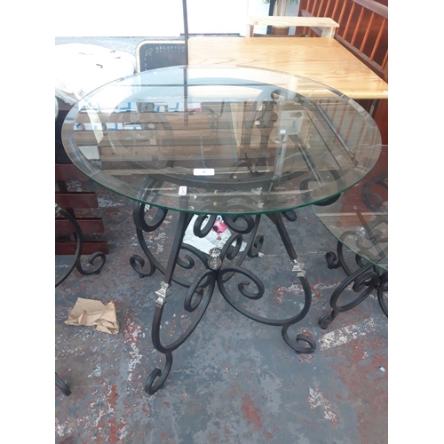 26 - A BLACK METAL ORNATE FLORIST DISPLAY TABLE WITH CIRCULAR GLASS TOP