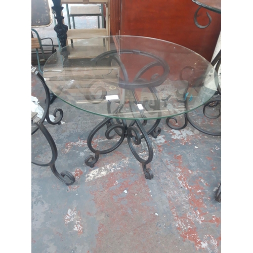 27 - A SMALL BLACK METAL ORNATE FLORIST DISPLAY TABLE WITH CIRCULAR GLASS TOP