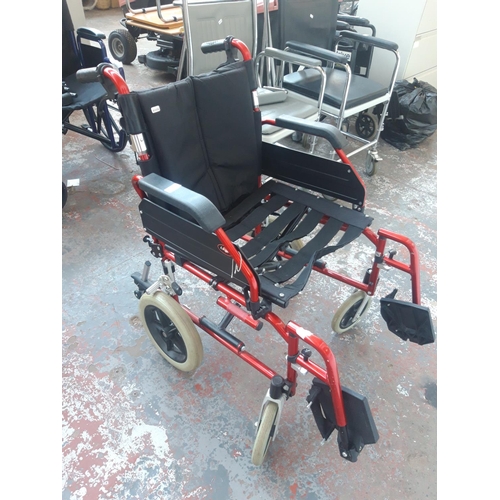 40 - A RED ENIGMA WHEELCHAIR WITH FOOTRESTS AND BRAKES