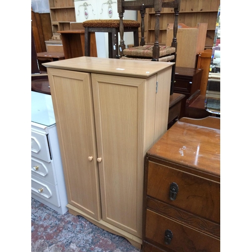 613 - AN OAK EFFECT STORAGE CUPBOARD WITH TWO DOORS