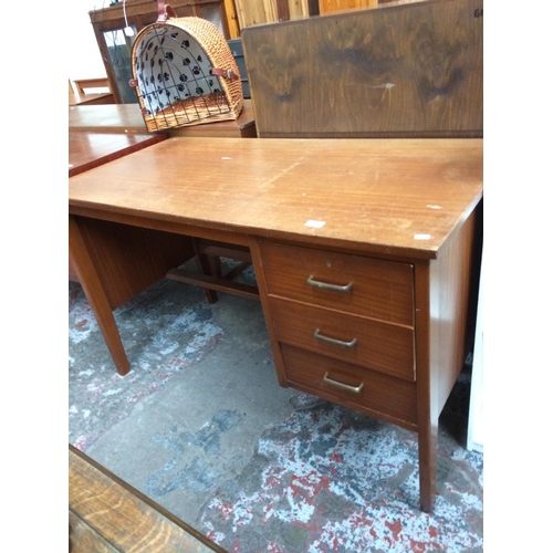 614 - A TEAK DESK WITH THREE DRAWERS