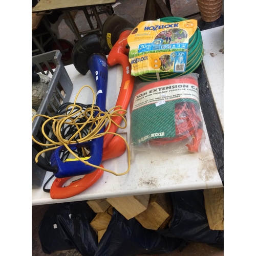 141 - FOUR ITEMS TO INCLUDE AN ORANGE FLYMO POWER TRIM ELECTRIC STRIMMER, HOZELOCK GARDEN HOSE, BLACK & DE... 