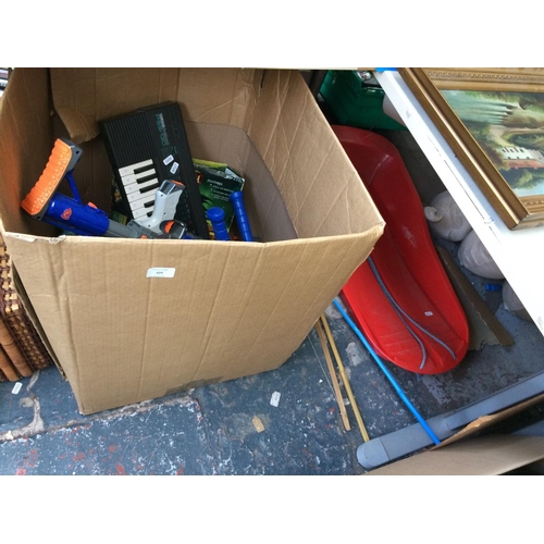 325 - A BOX CONTAINING MIXED TOYS TO INCLUDE KEYBOARD W/O, NERF GUN ETC AND A RED PLASTIC SLEDGE